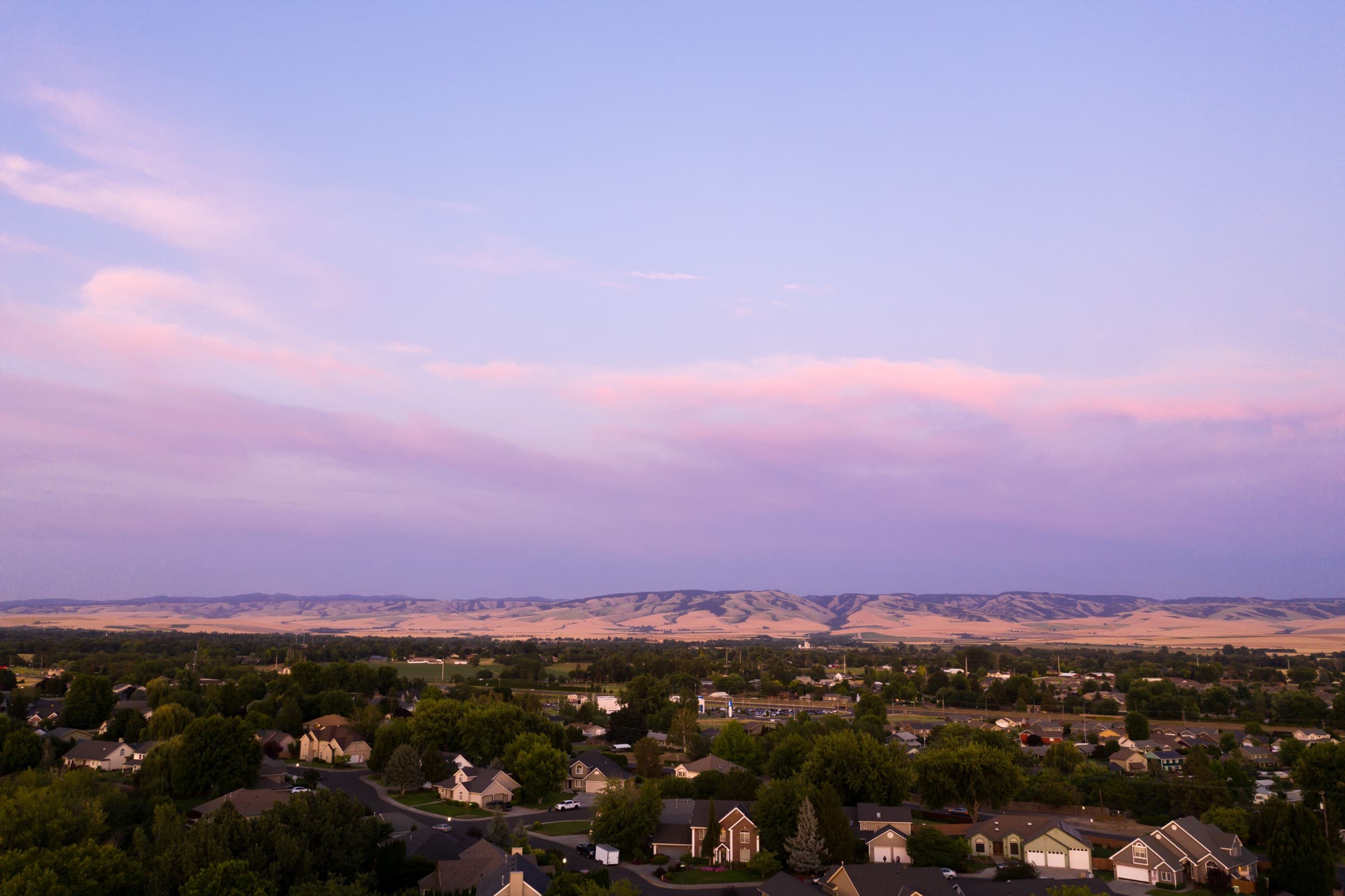Aerial view of a Pasco neighborhood at dusk with the hills beyond